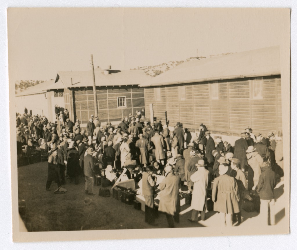 Internees standing outside barracks with their luggage at the Santa Fe Internment Camp circa 1942 to 1946.